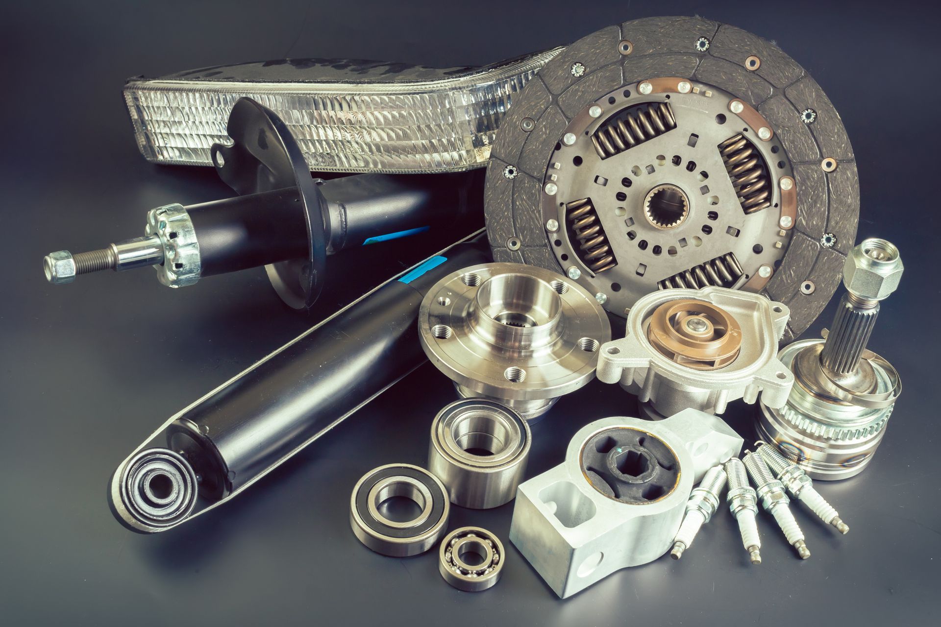 Selection of hydraulic and non-hydraulic car parts on top of a gray surface.