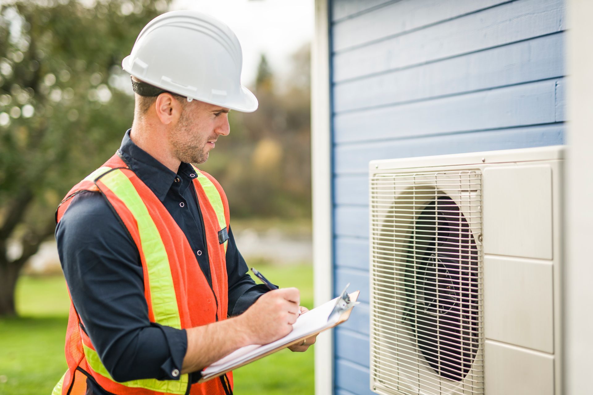 A technician working on an air conditioning outdoor unit.