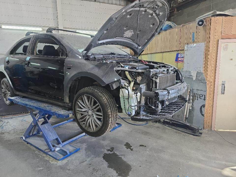 Black Car on a Lift With Hood Open in a Garage, Front Bumper Removed — T & C Smash Repairs In Coffs Harbour, NSW