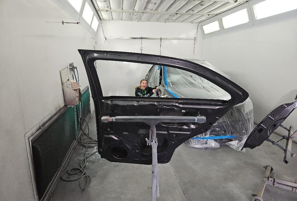 Car Door on a Stand in a Paint Booth, Being Worked on by a Person — T & C Smash Repairs In Coffs Harbour, NSW