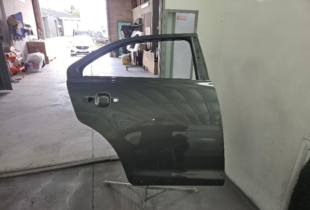 Newly Painted Car Door in a Workshop — T & C Smash Repairs In Coffs Harbour, NSW