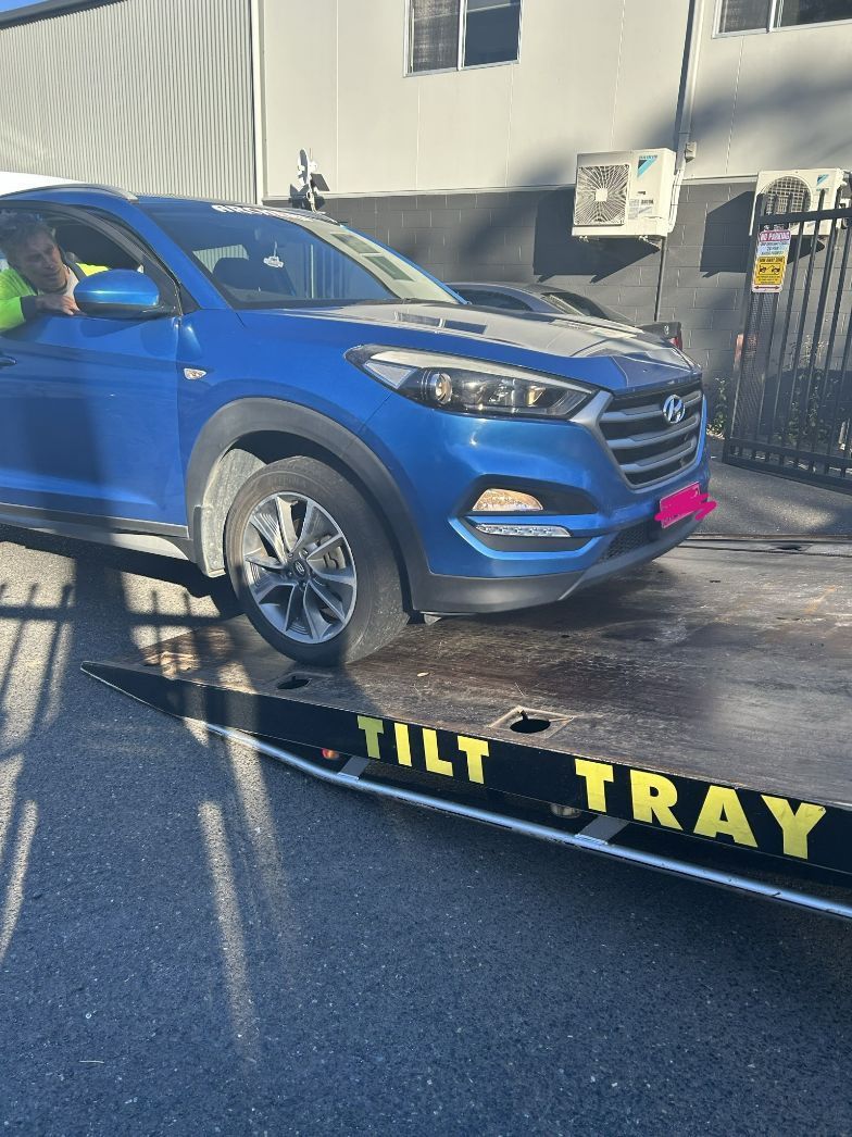 Blue Hyundai Tucson on a Tilt Tray Tow Truck — T & C Smash Repairs In Coffs Harbour, NSW