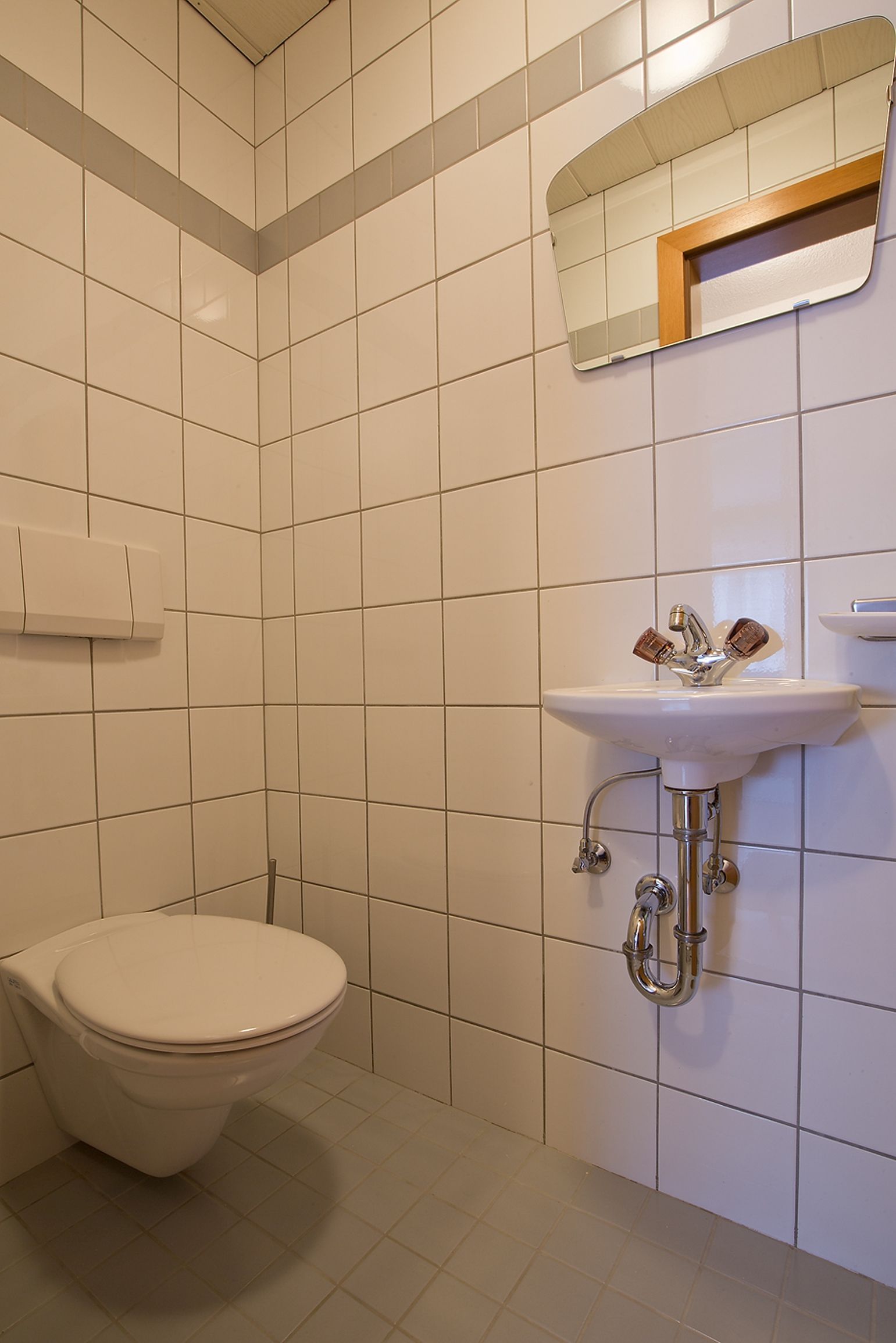 Ein Badezimmer mit Toilette, Waschbecken und Spiegel