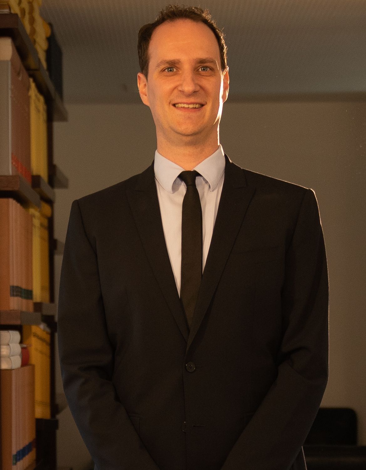 A man in a suit and tie is smiling for the camera