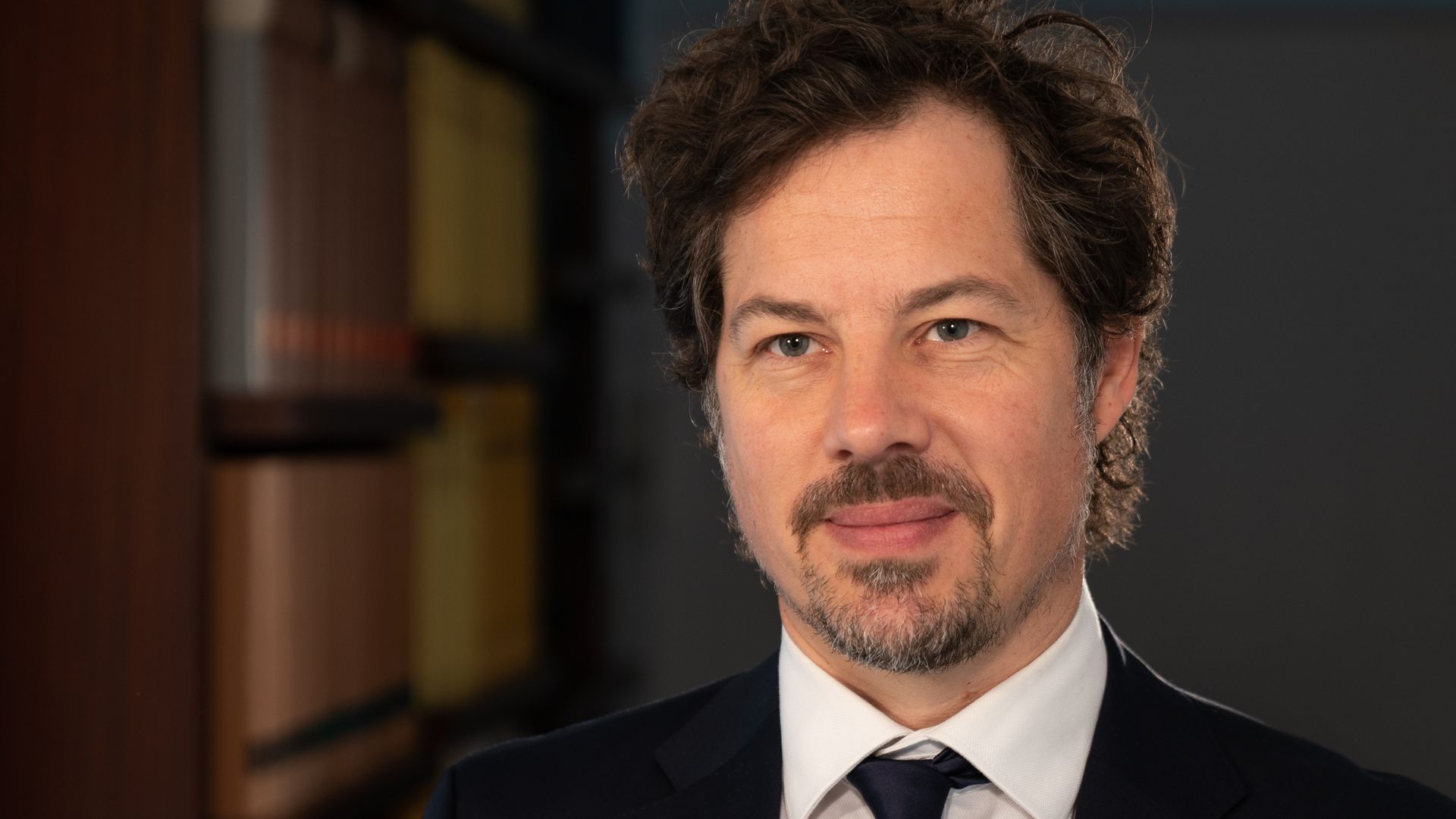 Ein Mann mit Bart trägt Anzug und Krawatte.