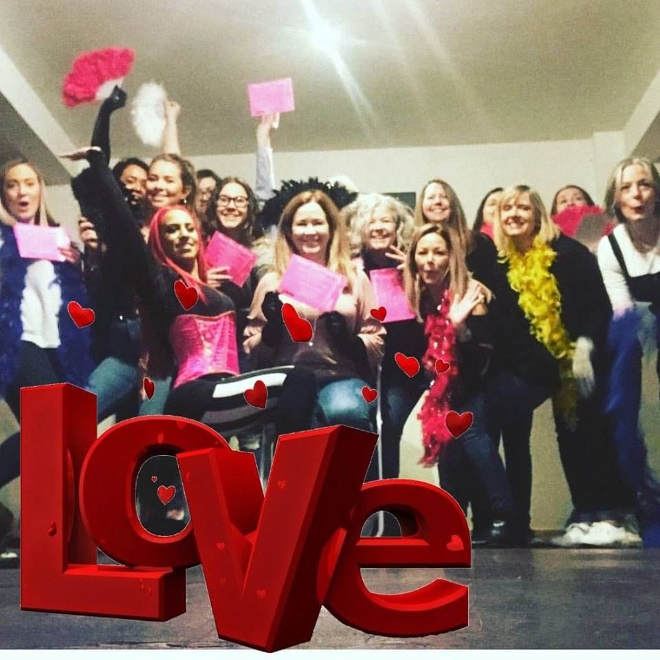 Hen group posing with big red LOVE letters at their dance party celebration