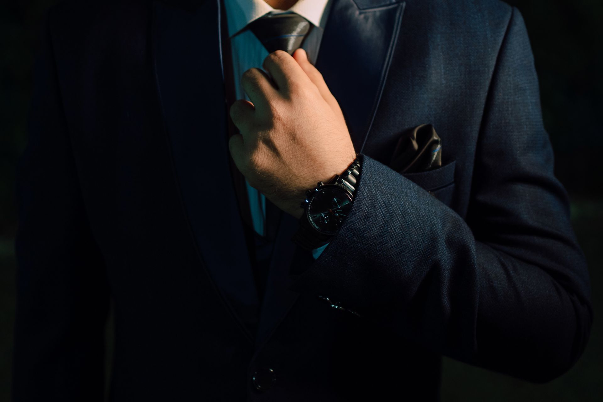 Businessman adjusting his tie and suit jacket before a corporate event