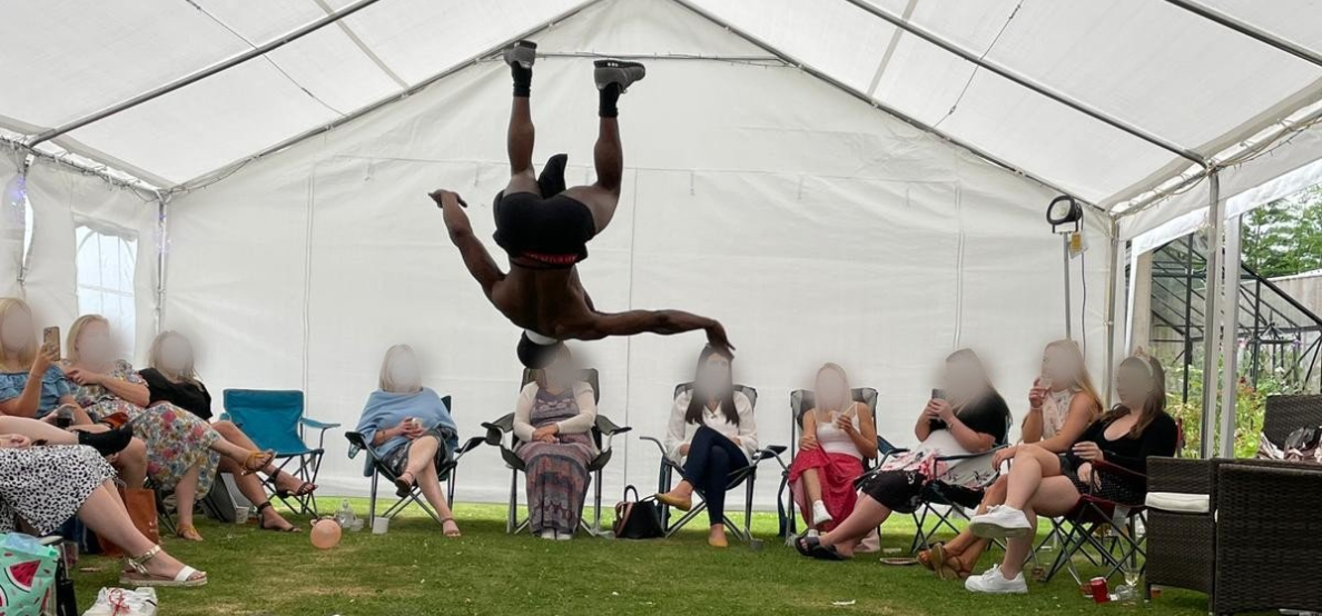 Buff butler performing an acrobatic move during a hen party entertainment session
