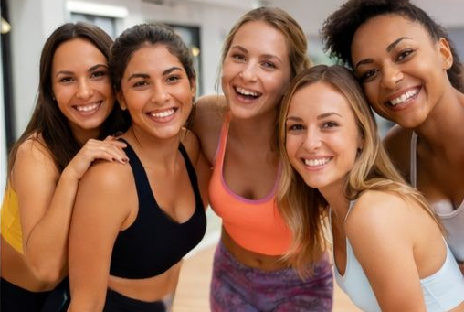 Smiling group of women at a friendly beginner dance fitness class in a Cardiff studio after their workout