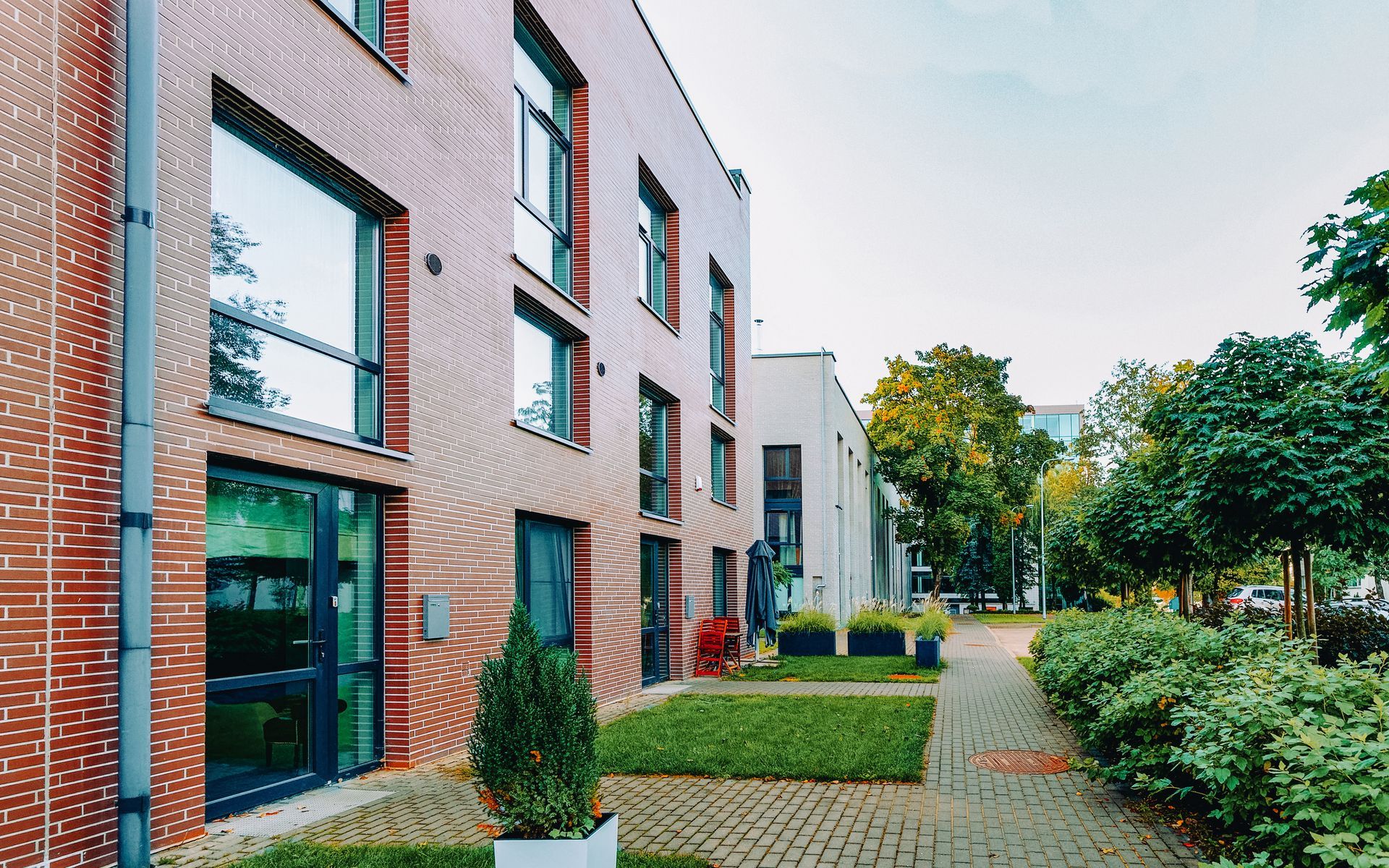 A large brick building with a lot of windows and a walkway in front of it.