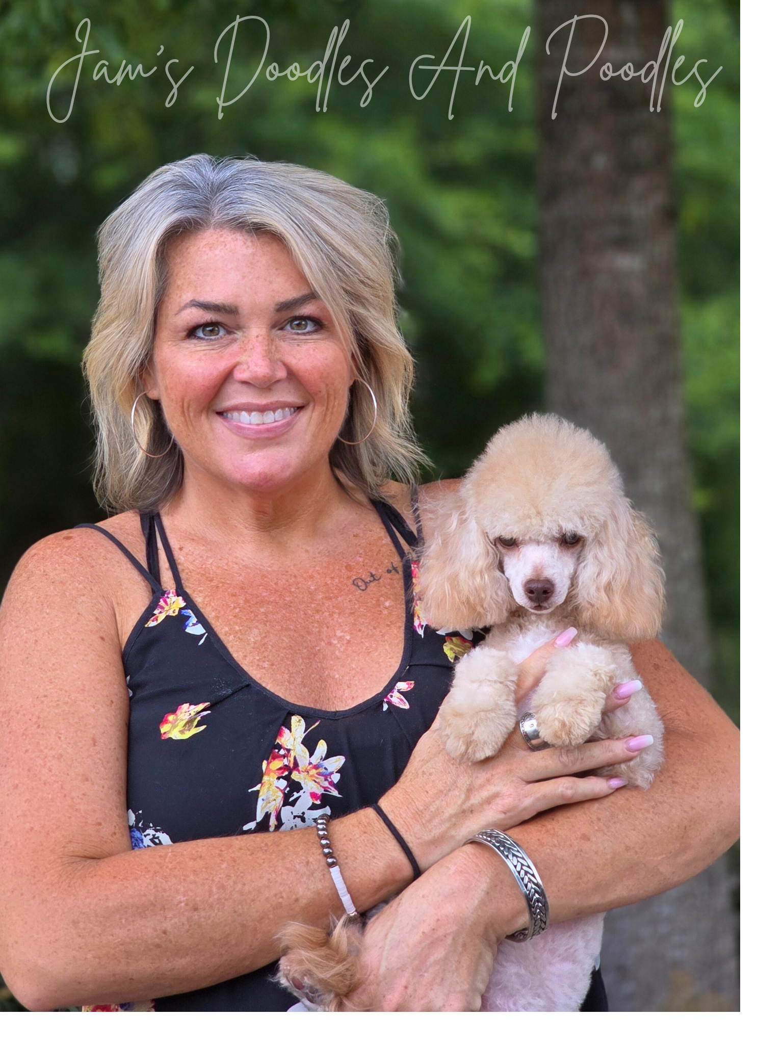 Woman holding a cream-colored poodle, smiling. 