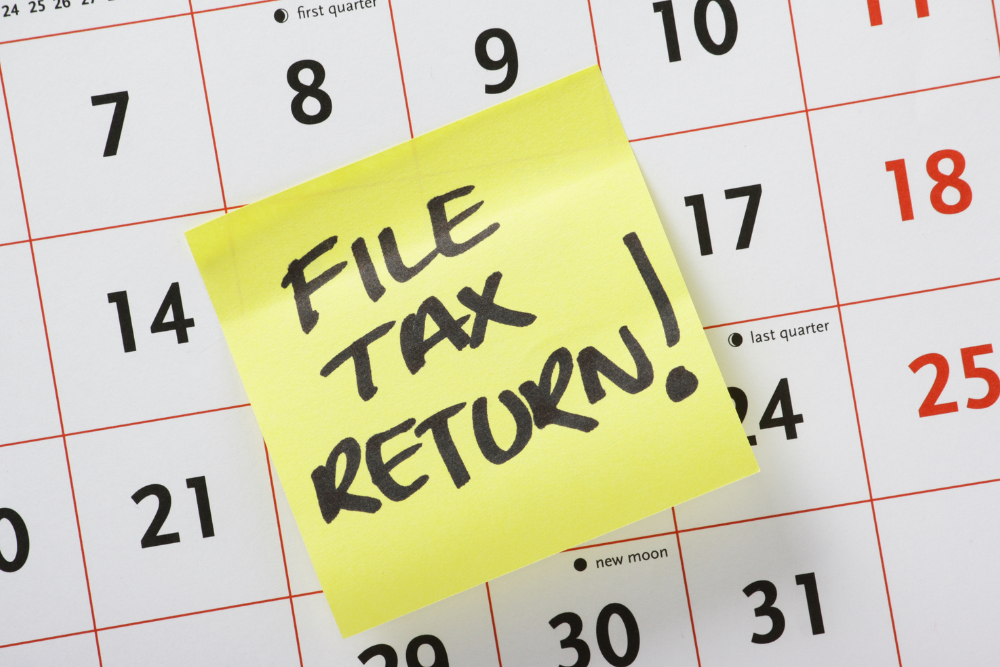A calendar with a yellow sticky note that says file tax return