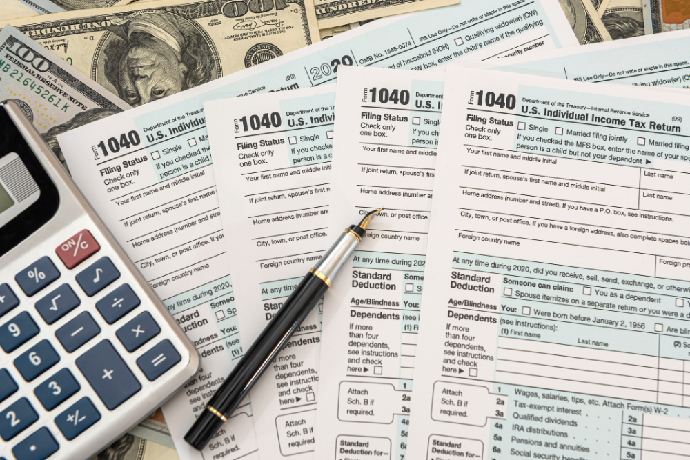 A calculator is sitting on top of a pile of tax forms.
