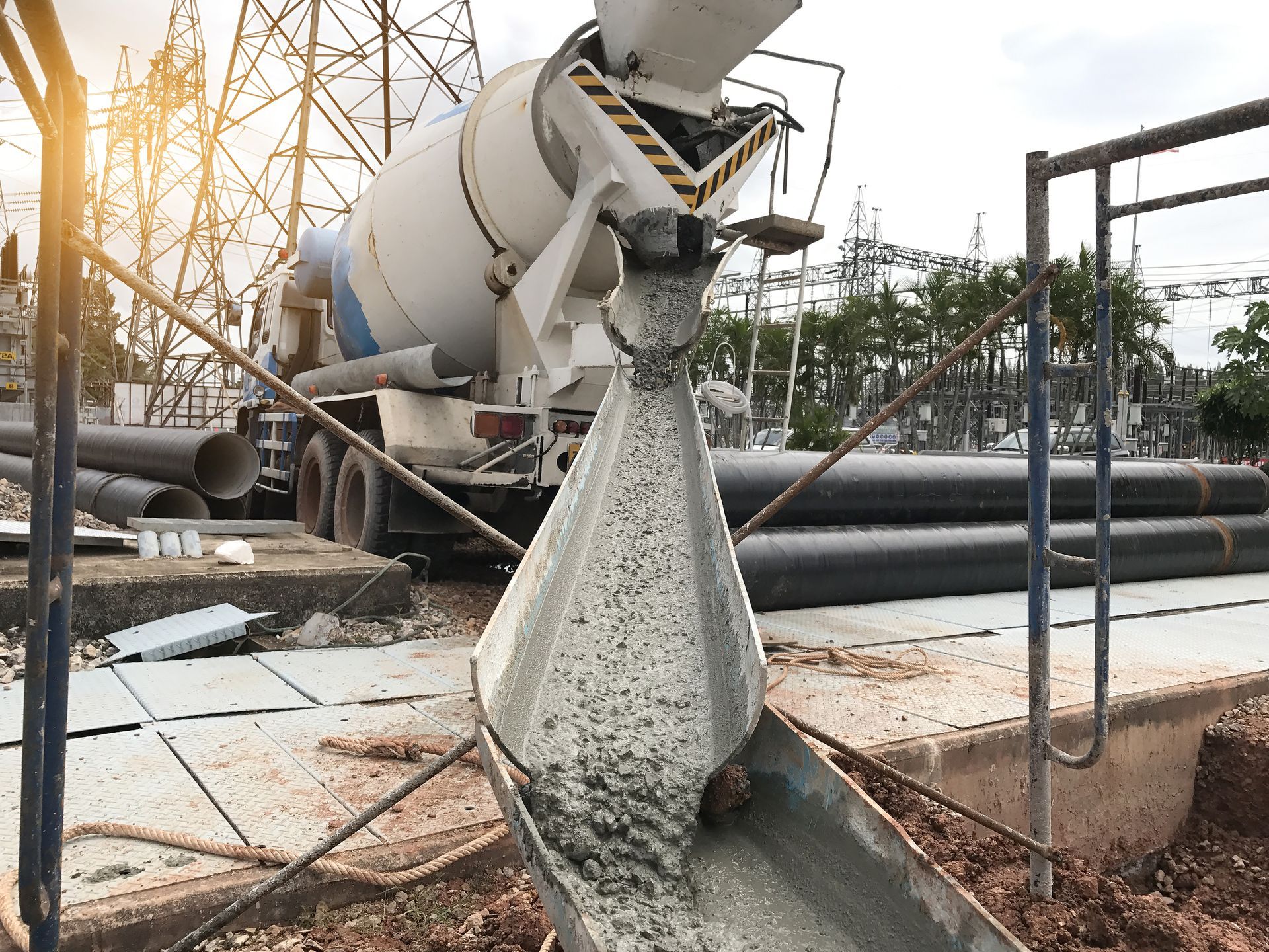 Concrete pouring from a mixer truck at a construction site.