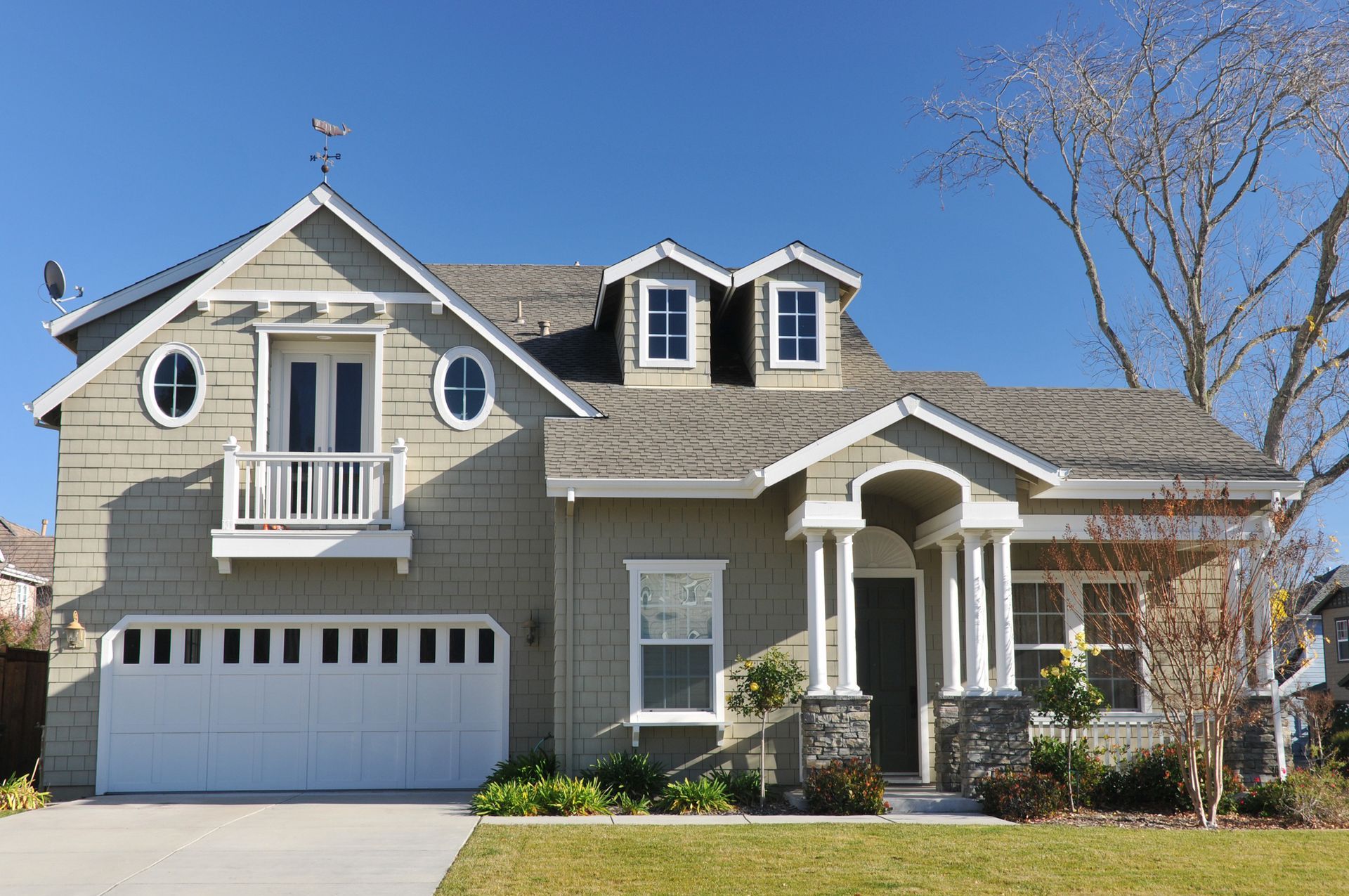 A large house with a white garage door and a balcony