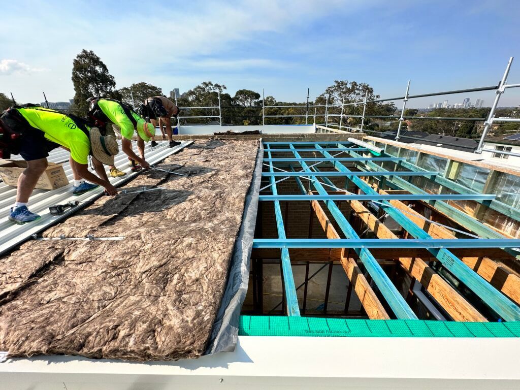 A group of construction workers are working on a roof.