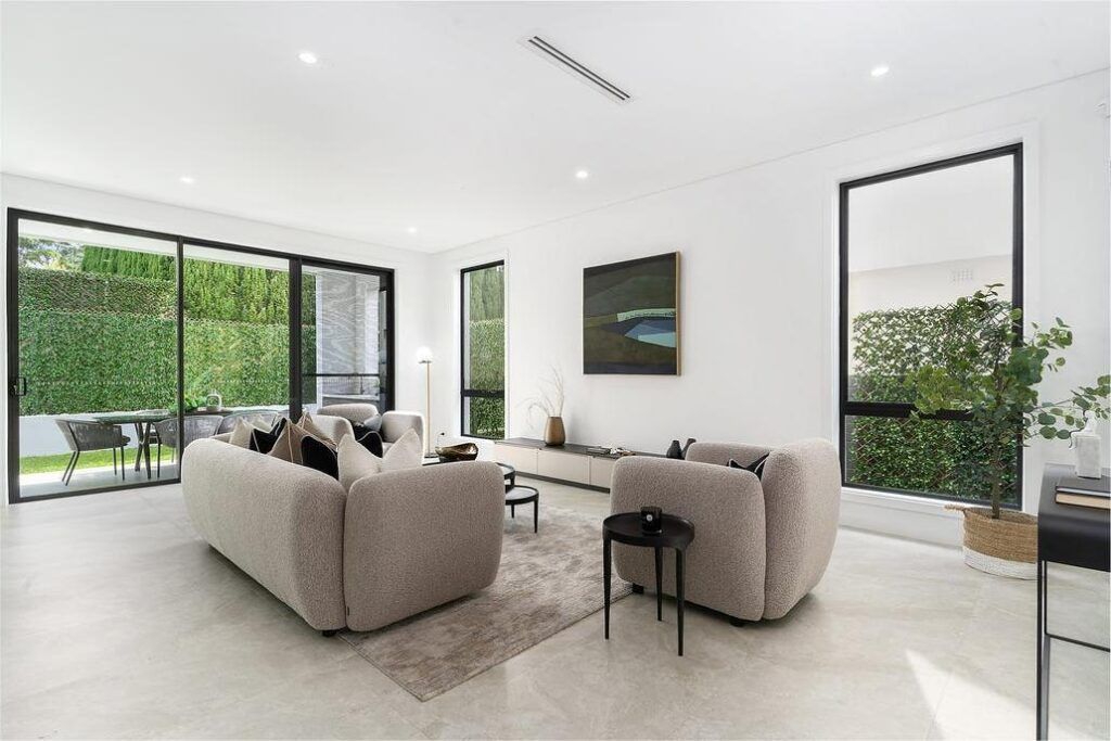 A living room with a large couch and two chairs