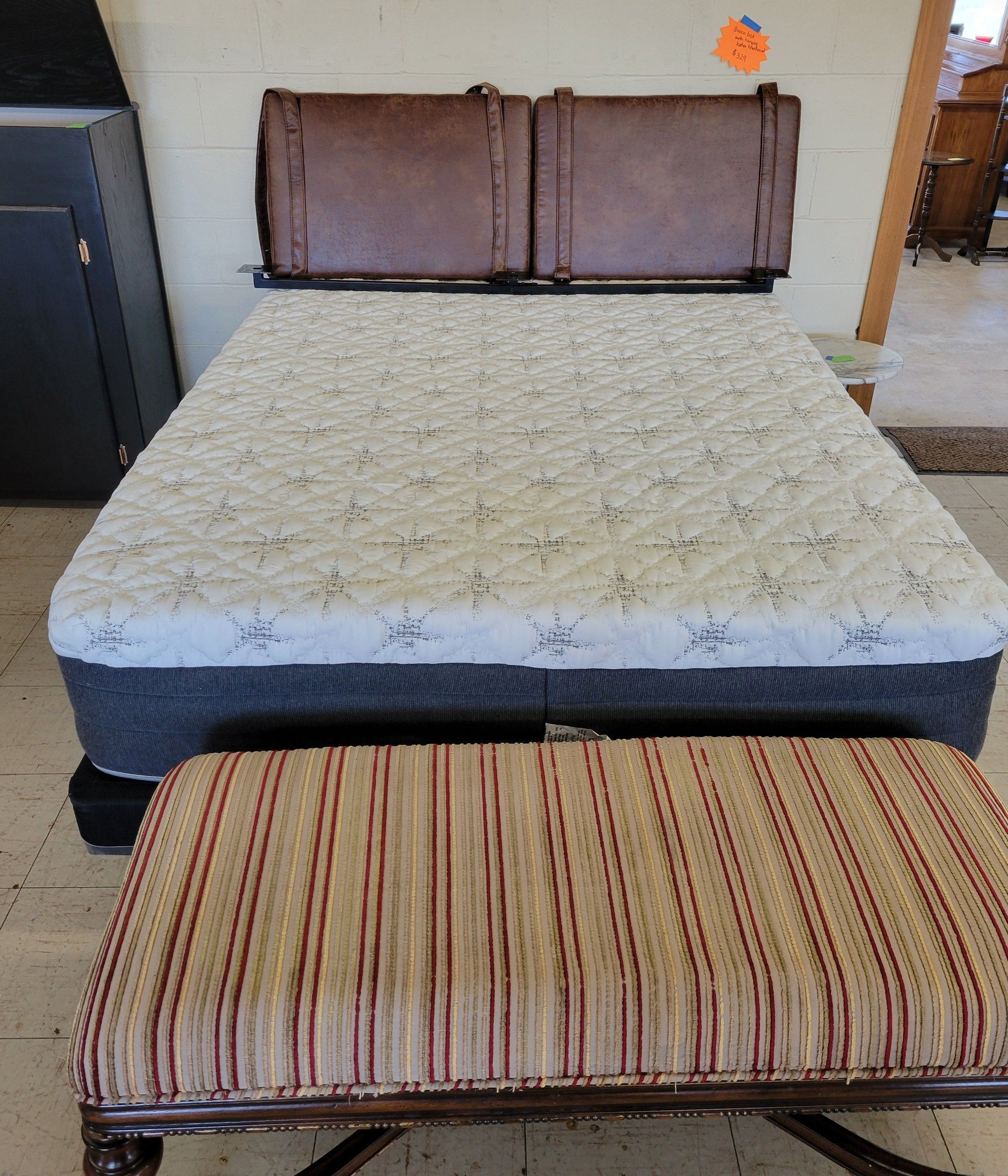 Black round dining table with four matching chairs on a floral rug. In a furniture store.