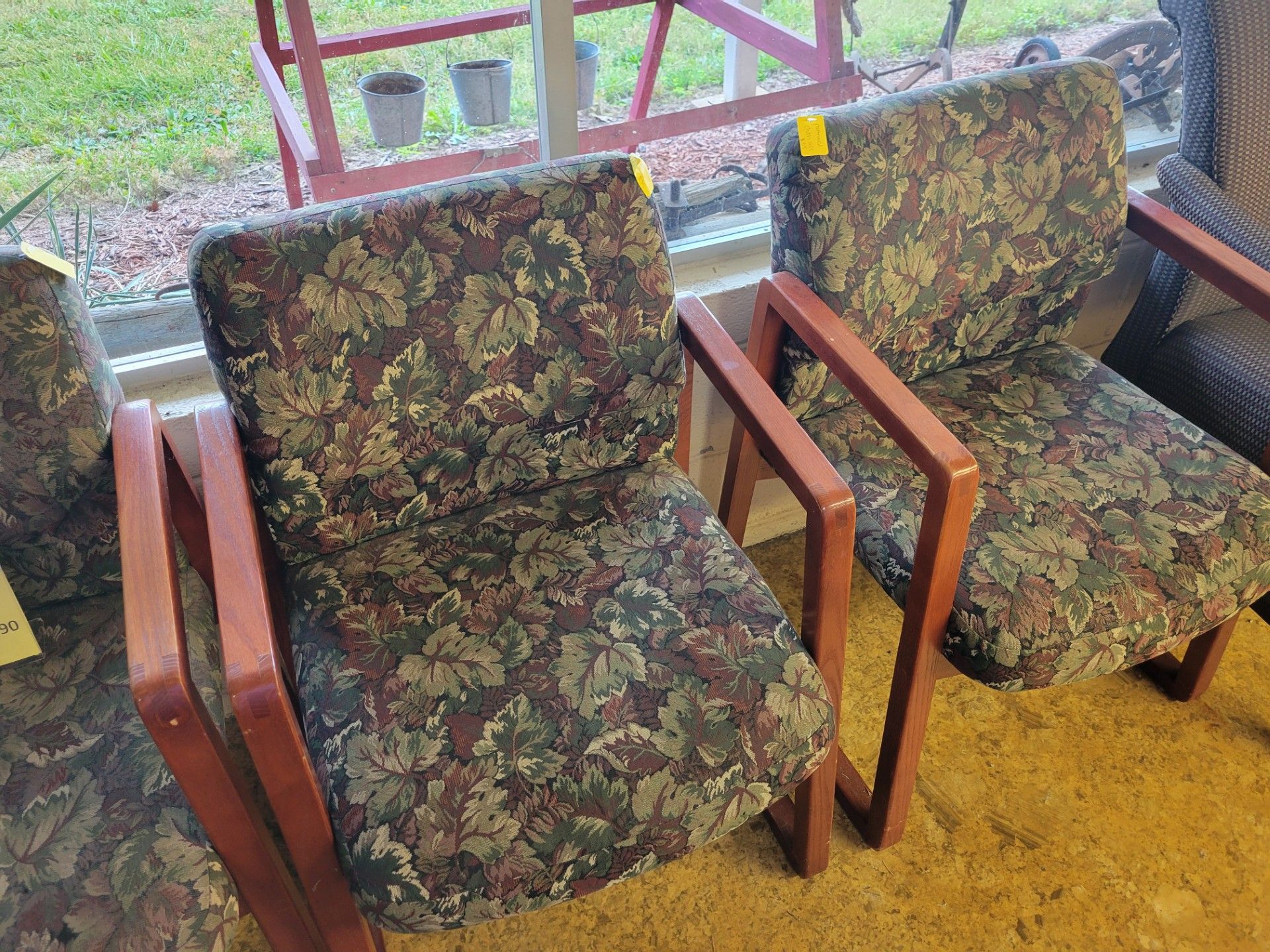 Two upholstered armchairs with floral pattern, brown wood frames.