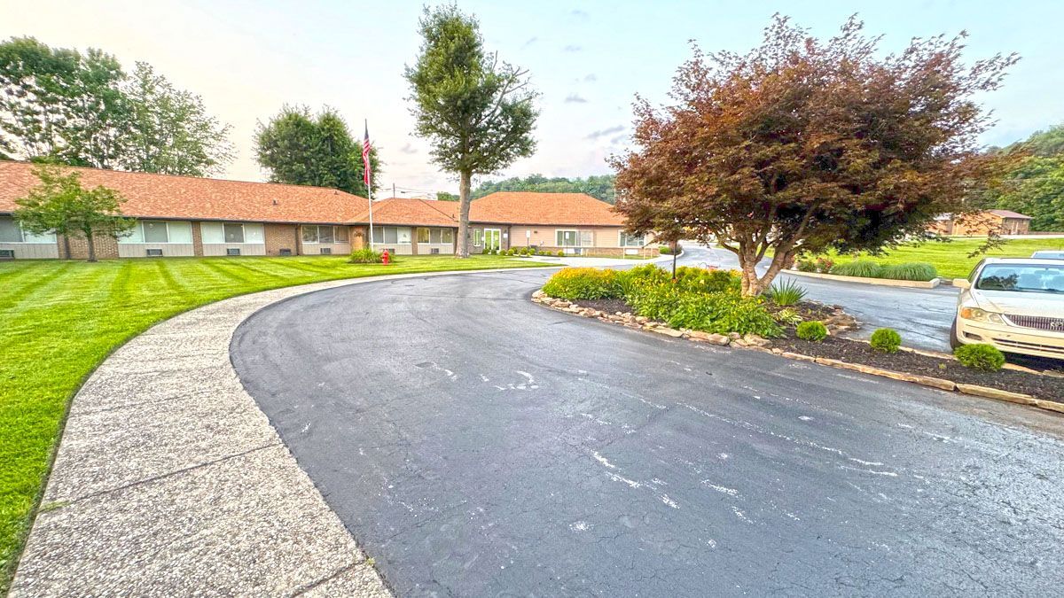 A car is parked on the side of the road in front of a house.
