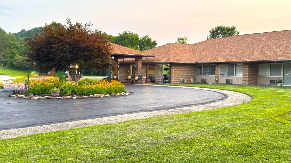 A large house with a tree in the middle of the driveway.
