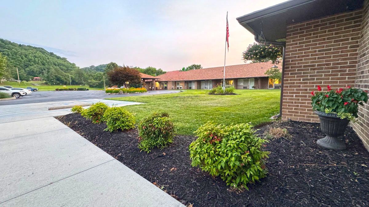 A brick building with a large lawn in front of it.