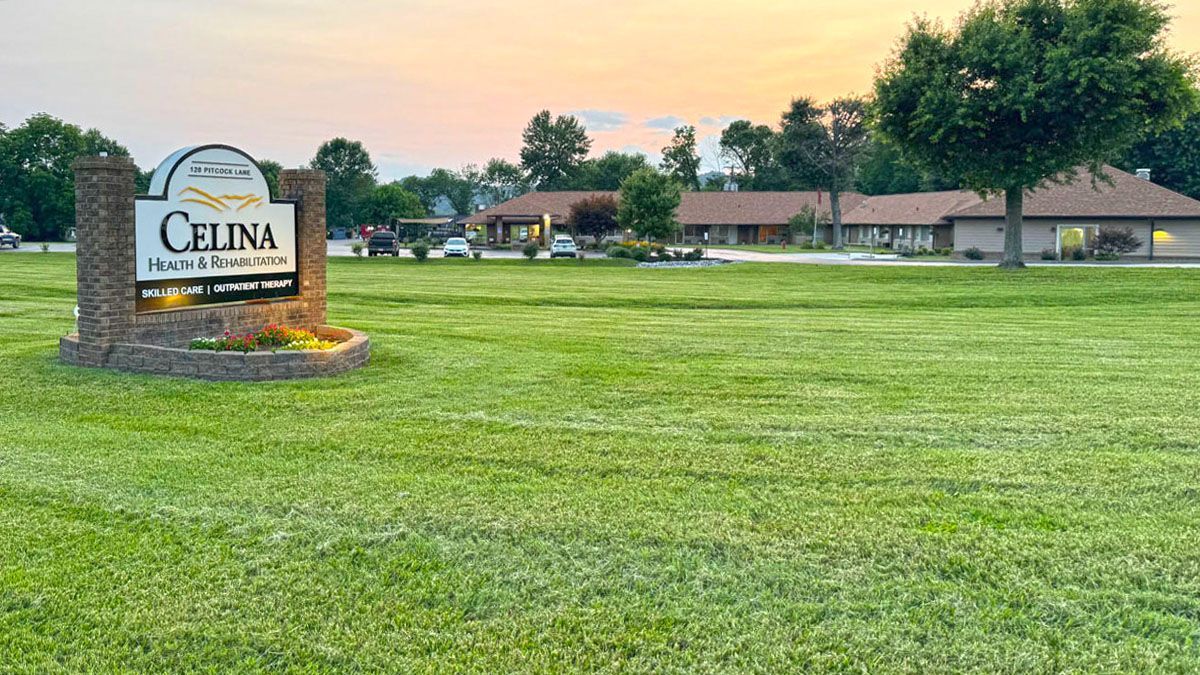 A large lush green field with a sign in the middle of it.