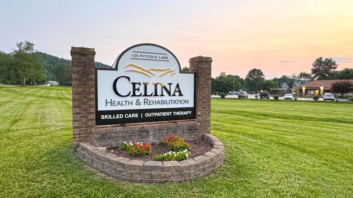 A sign for celina health and rehabilitation is in the middle of a grassy field.