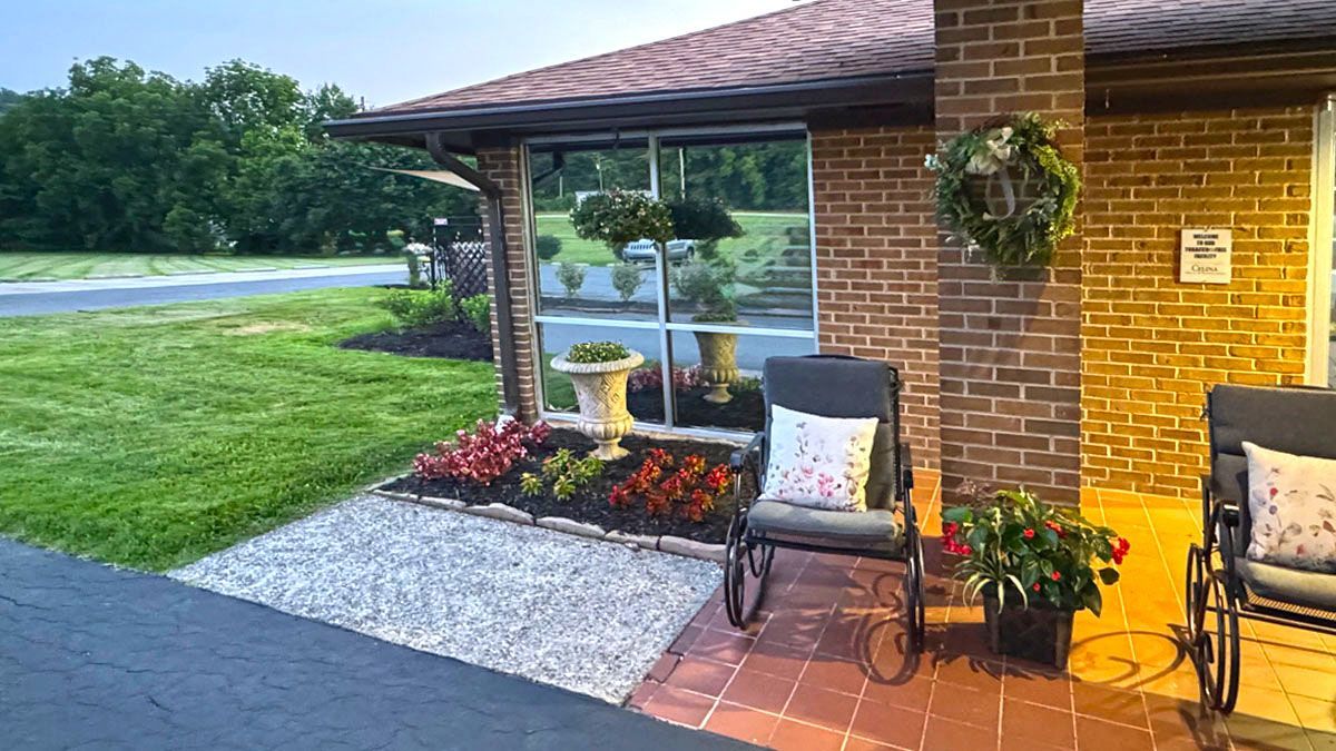 A brick house with chairs and a wheelchair in front of it.