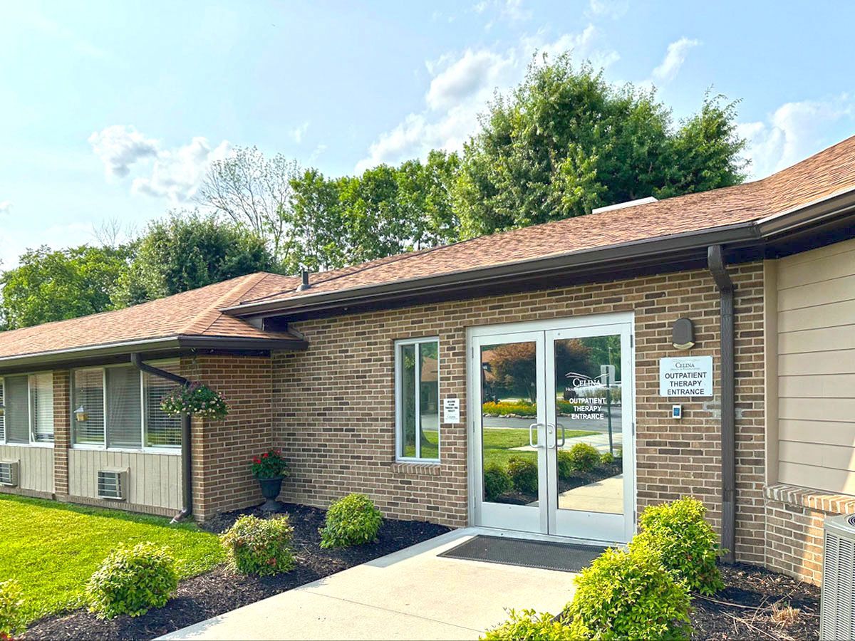A brick building with a white door and a walkway leading to it.