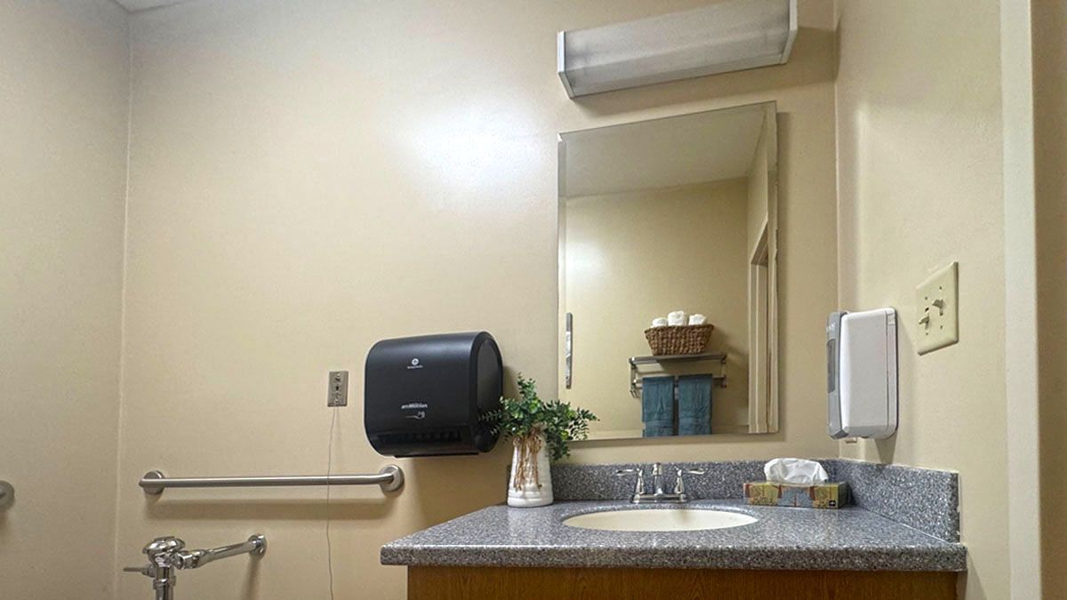 A bathroom with a sink , mirror and toilet.