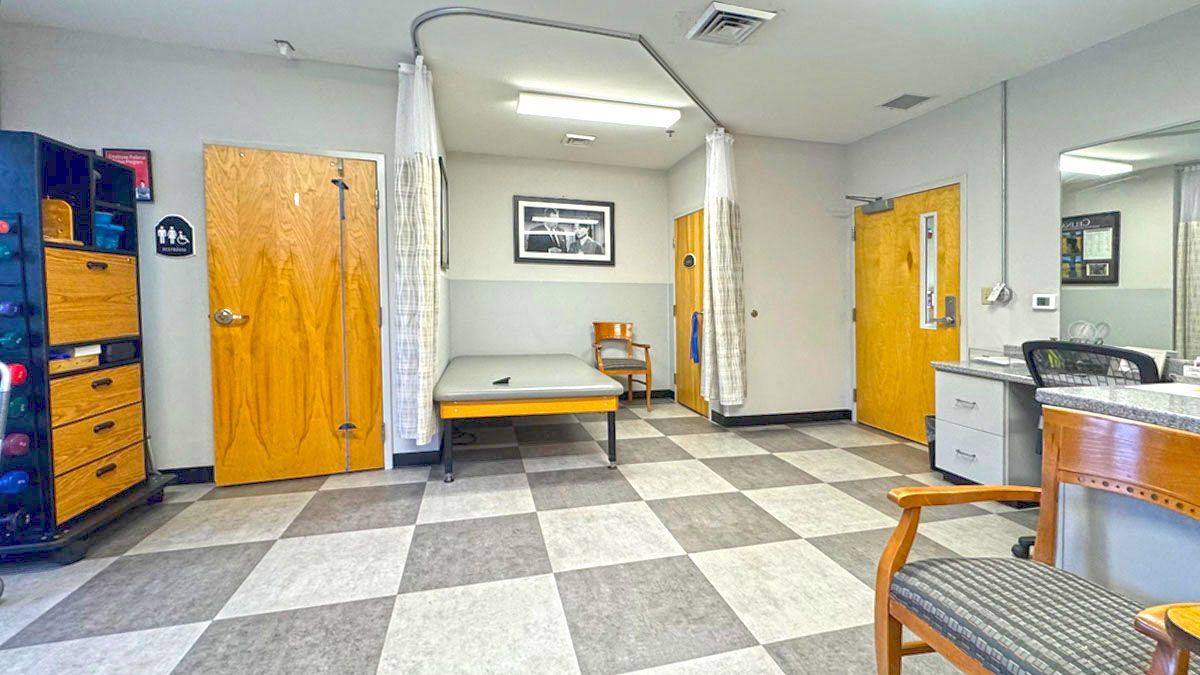 A room with a checkered floor and a bed in it.