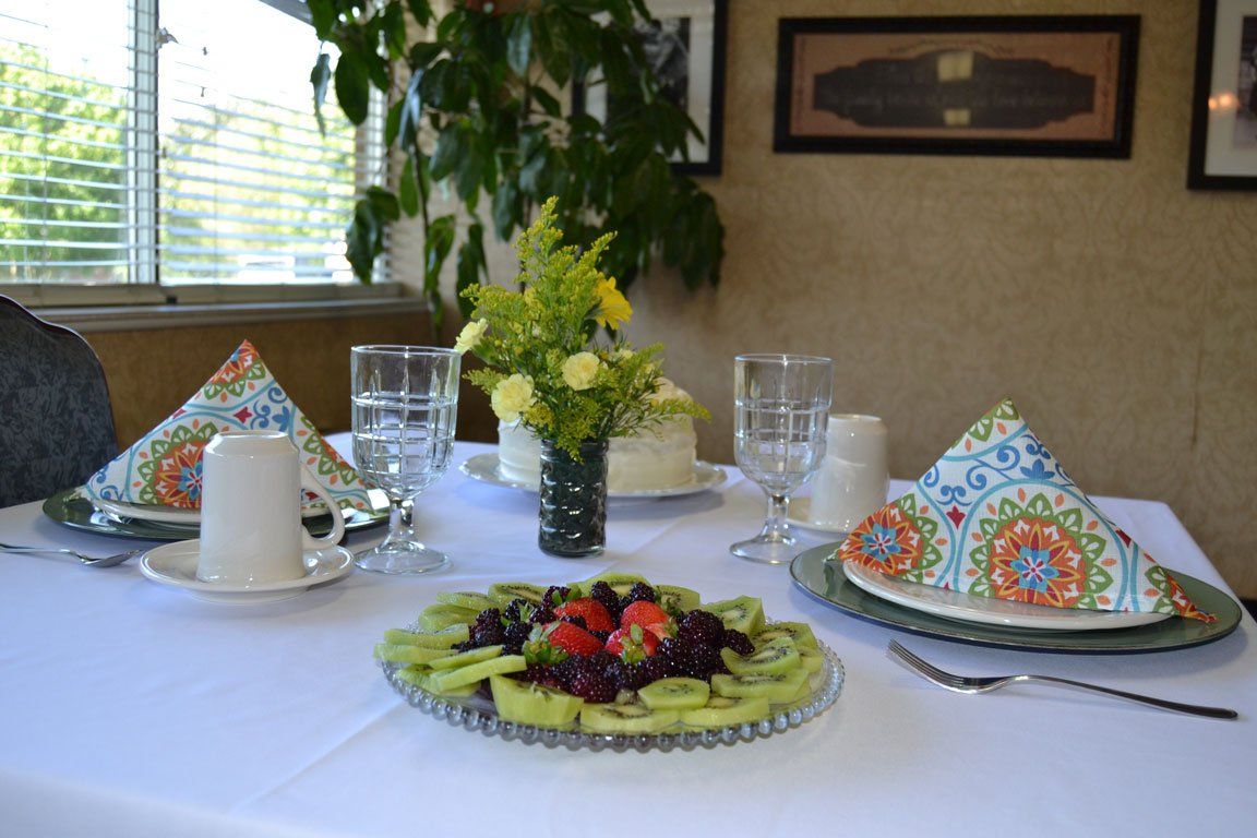 A table with a plate of fruit and a vase of flowers on it