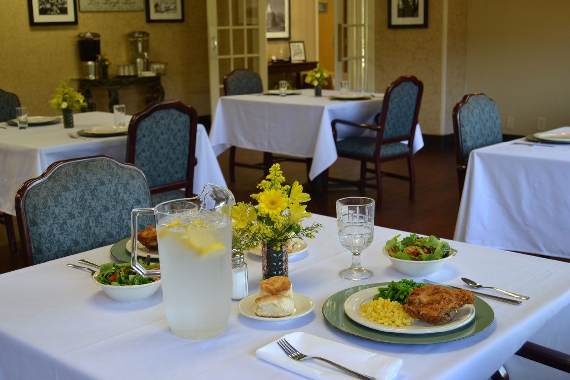 A dining room with tables and chairs and plates of food on them