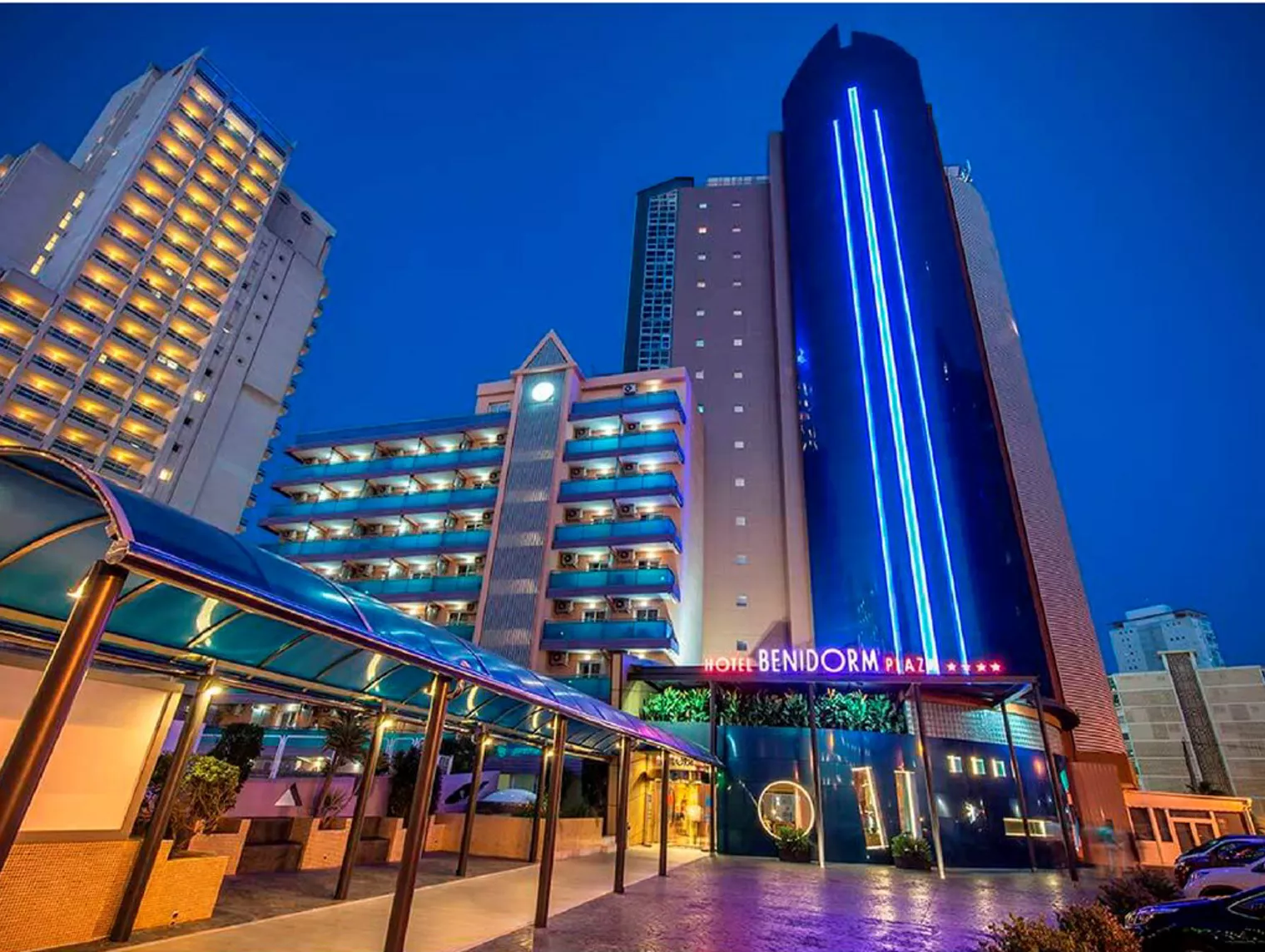 Hotel Benidorm Plaza at night with modern architecture and vibrant blue lighting in downtown