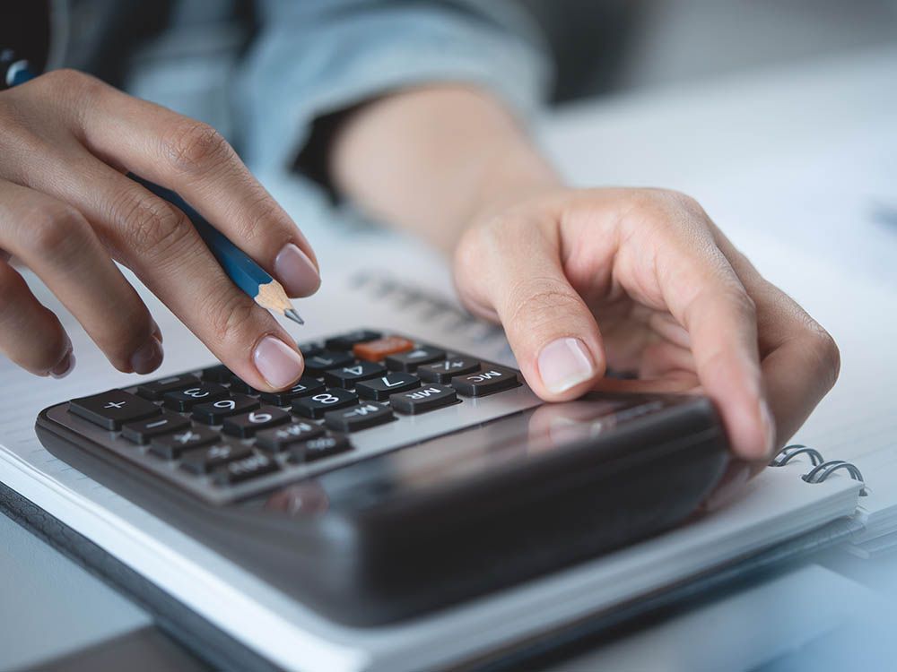 A person is using a calculator with a pen.