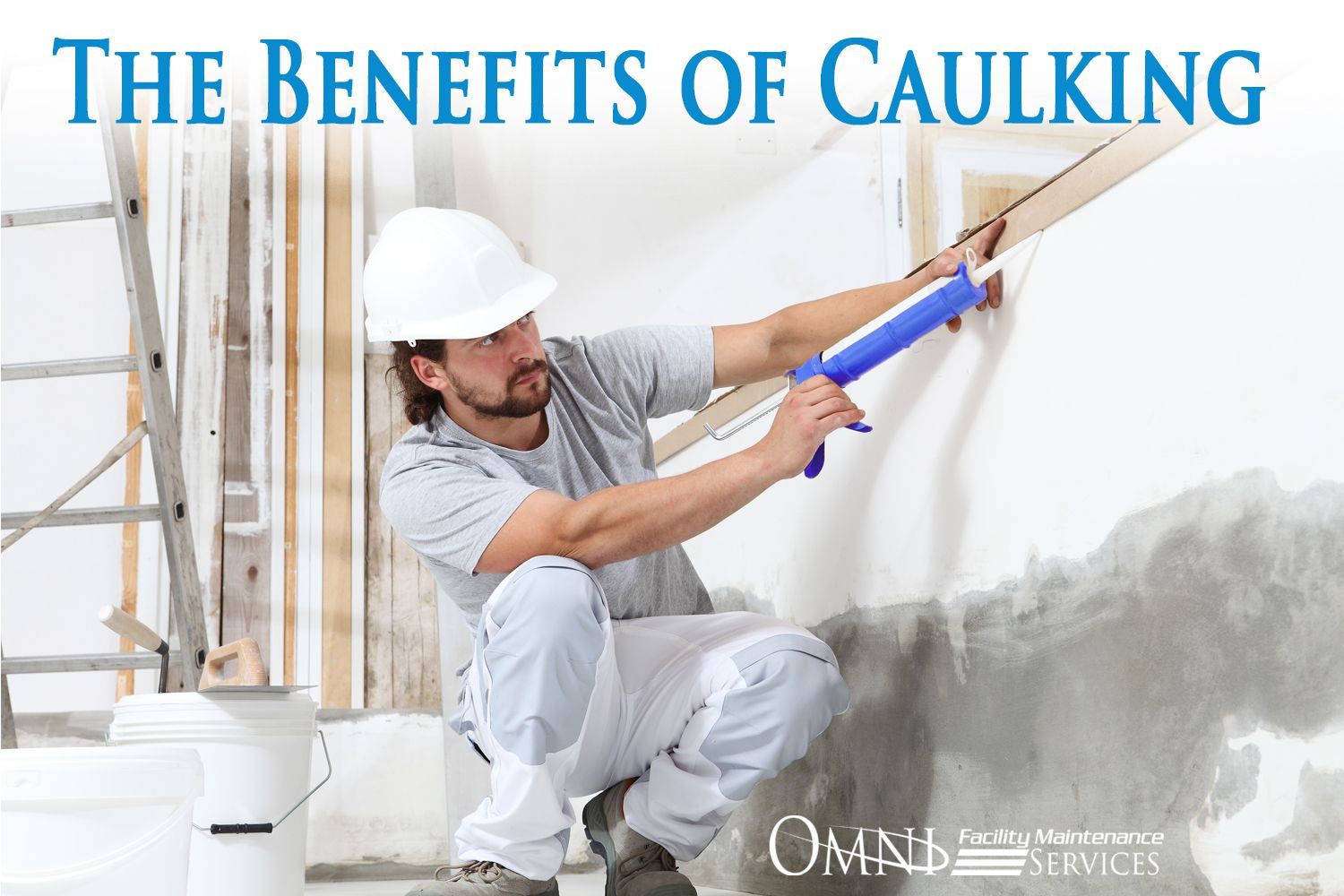 A man is kneeling down and applying caulking to a wall.