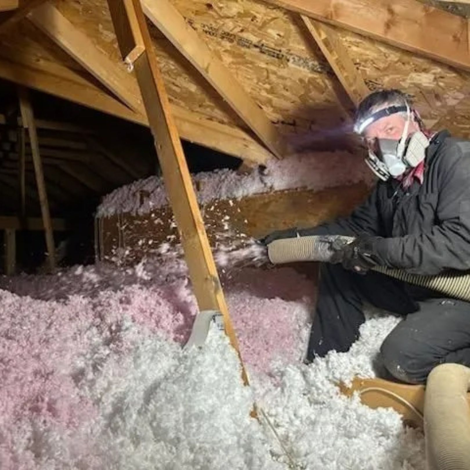 A bright bedroom with a slanted ceiling, a wooden bed frame, a white mattress, and a large arched window with a green view.