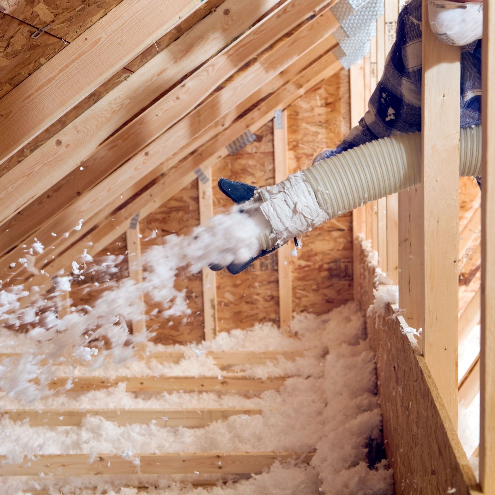 A sunlit attic room with a slanted wall, wooden flooring, and three skylight windows under a white ceiling.