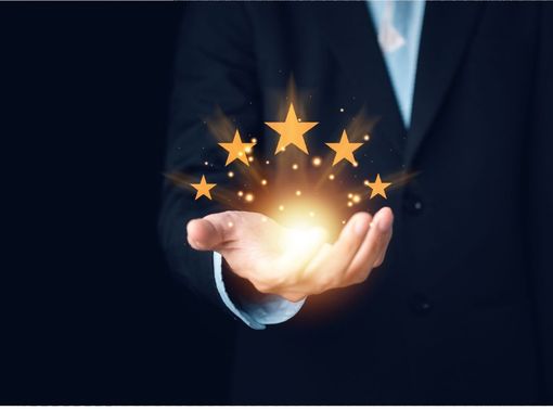 A man in a suit is holding glowing stars in his hands.