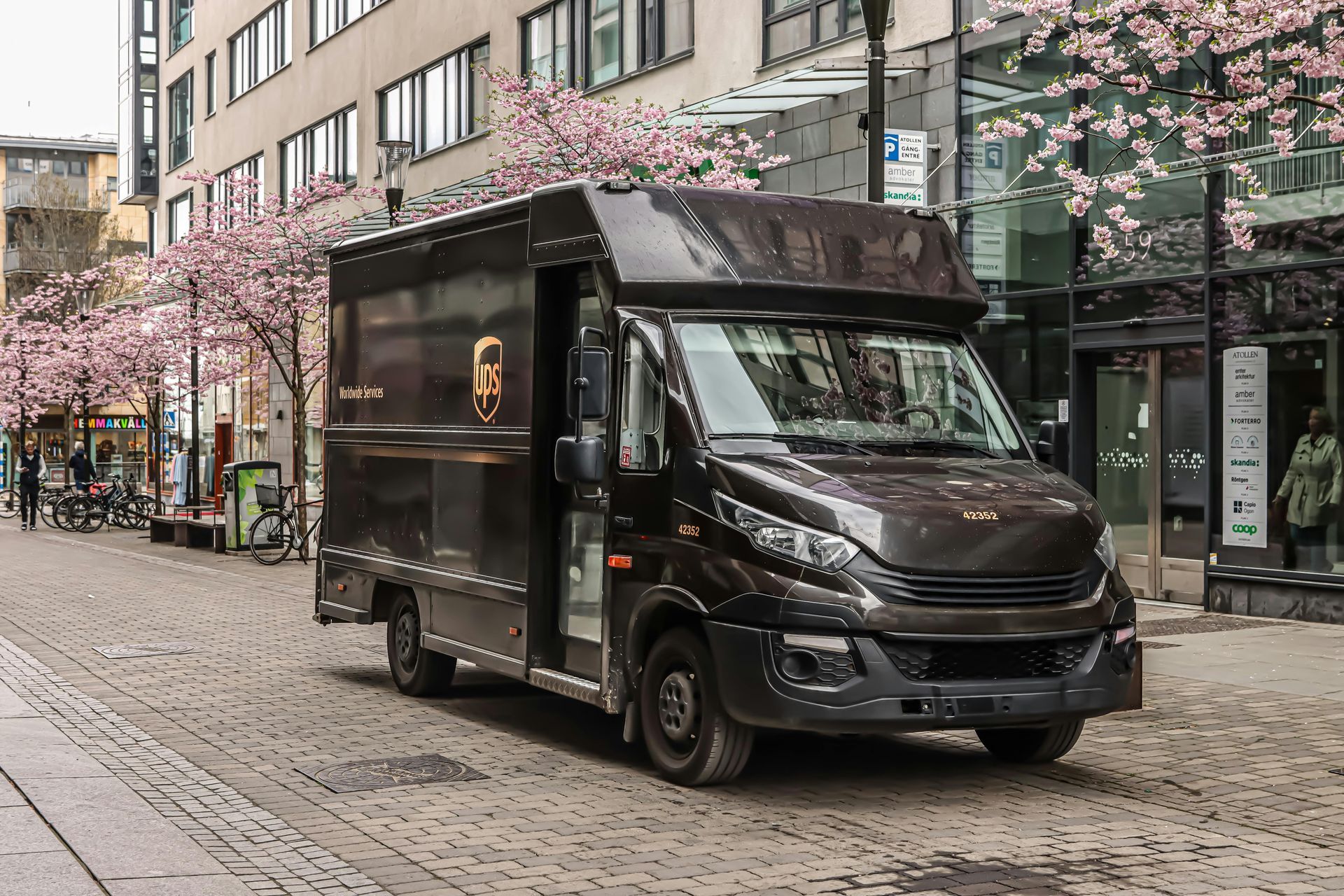 A ups delivery truck is driving down a city street.