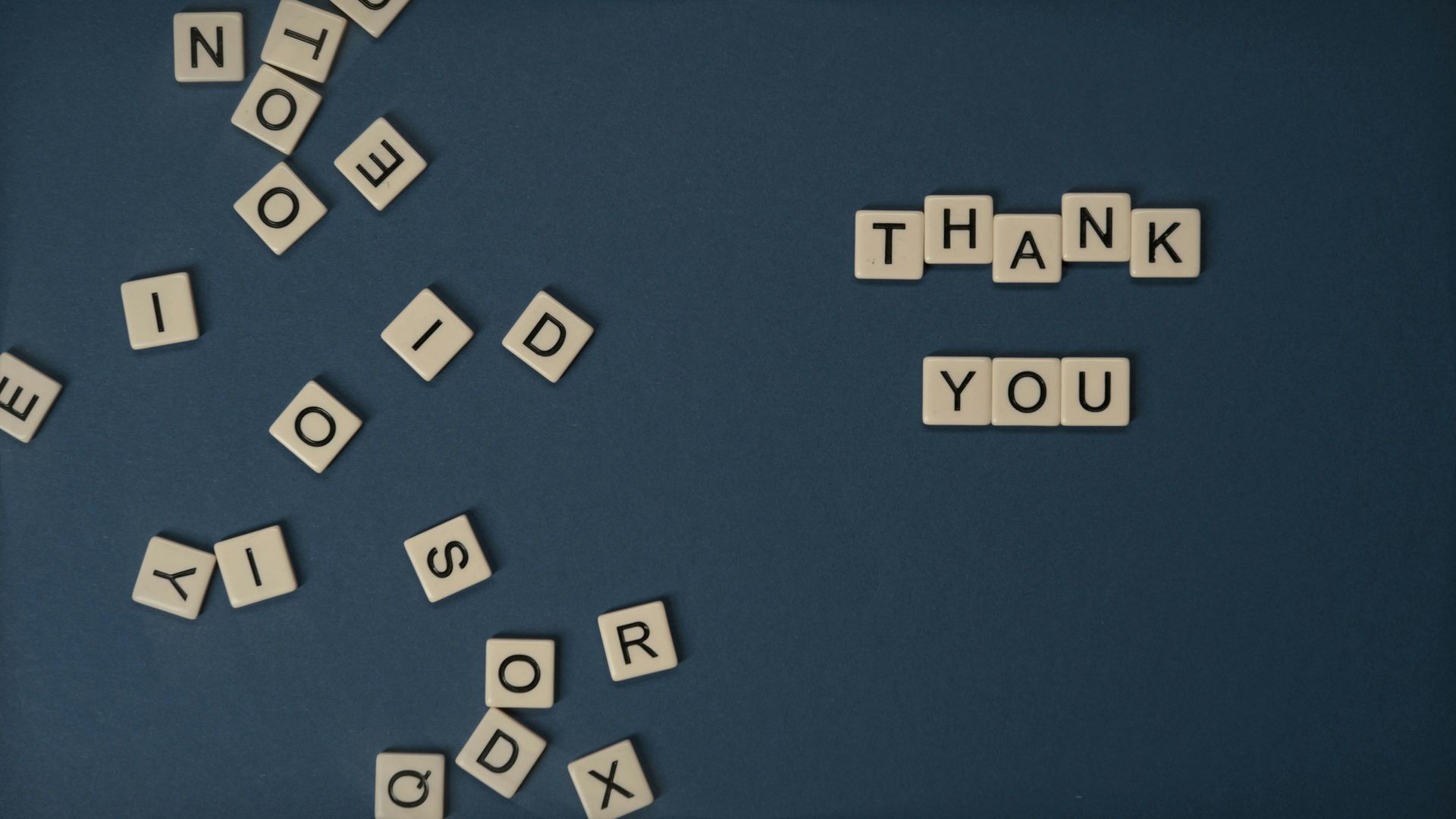 The word thank you is written in scrabble letters on a blue background.