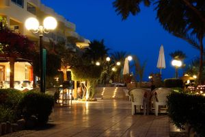 A row of tables and chairs in front of a building at night