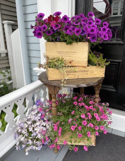 Purple and pink flowers in wooden boxes on a table
