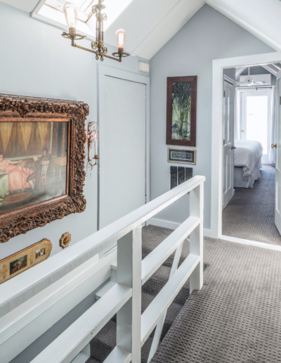 A hallway with stairs and a picture on the wall