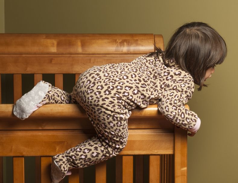 Toddler climbing out of a crib