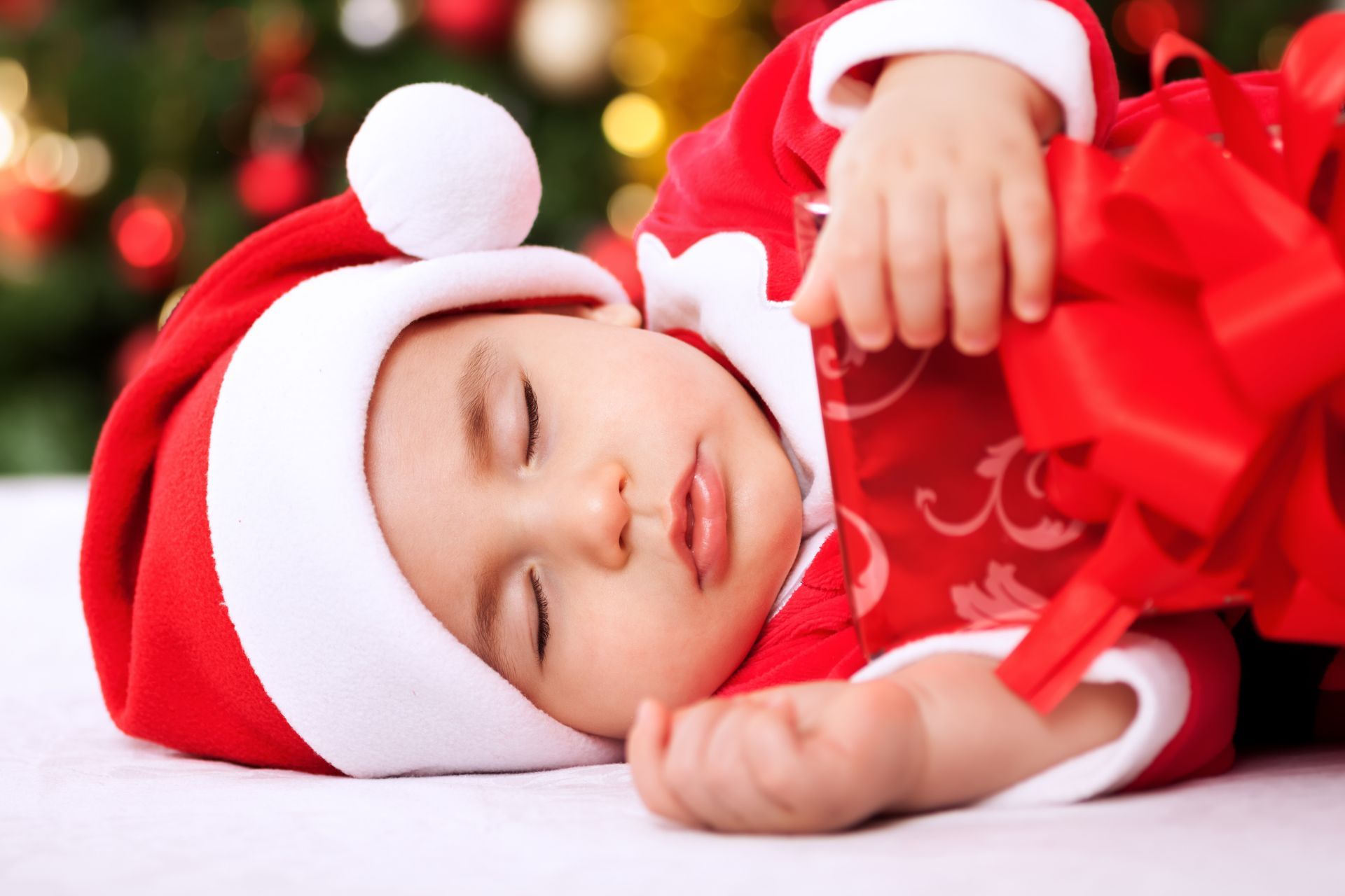 Sleepy baby dressed in Christmas outfit