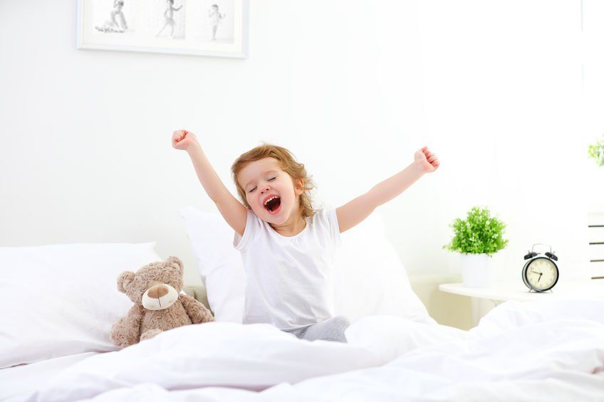 Kid waking up and yawning in bed