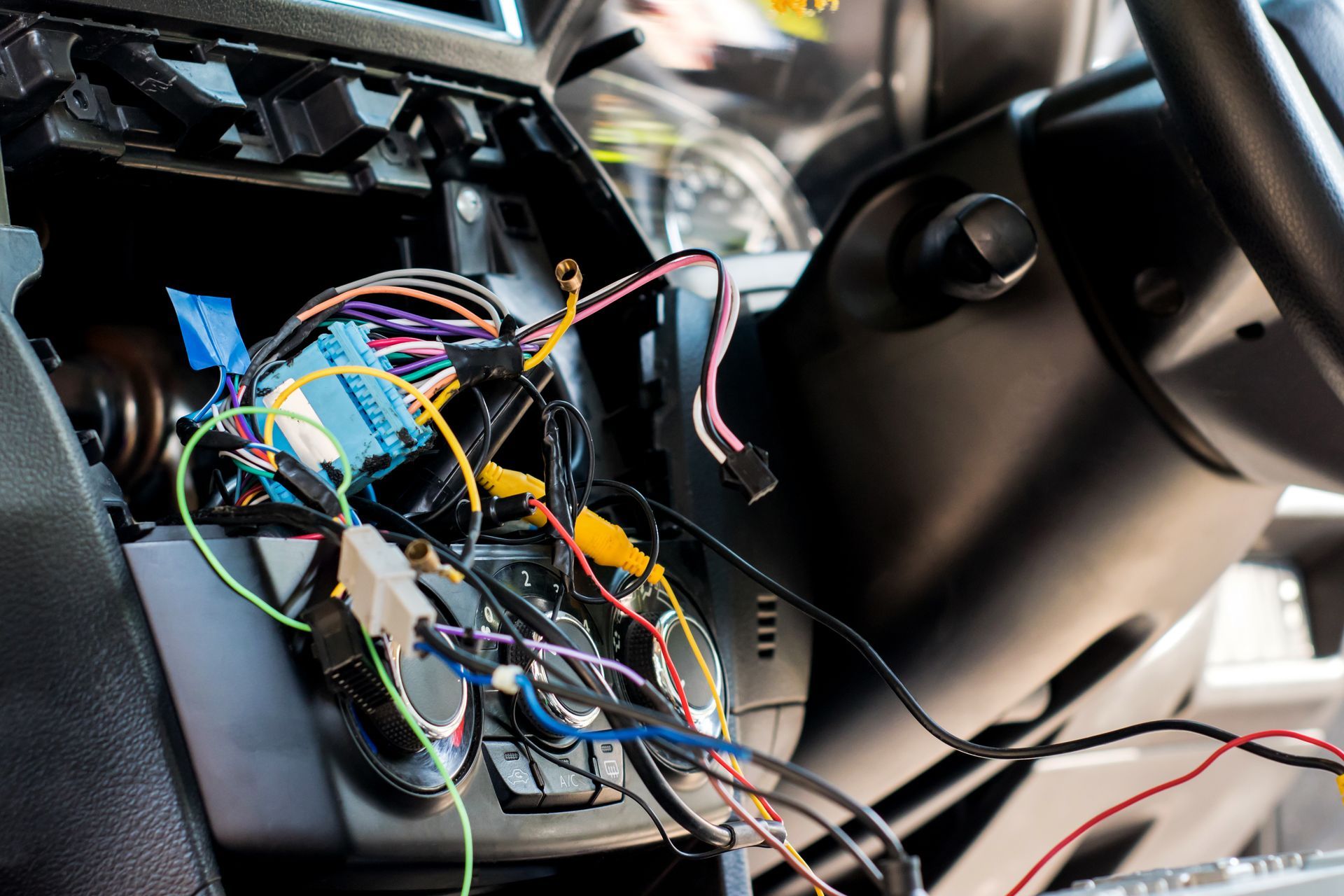 A bunch of wires are connected to a car dashboard