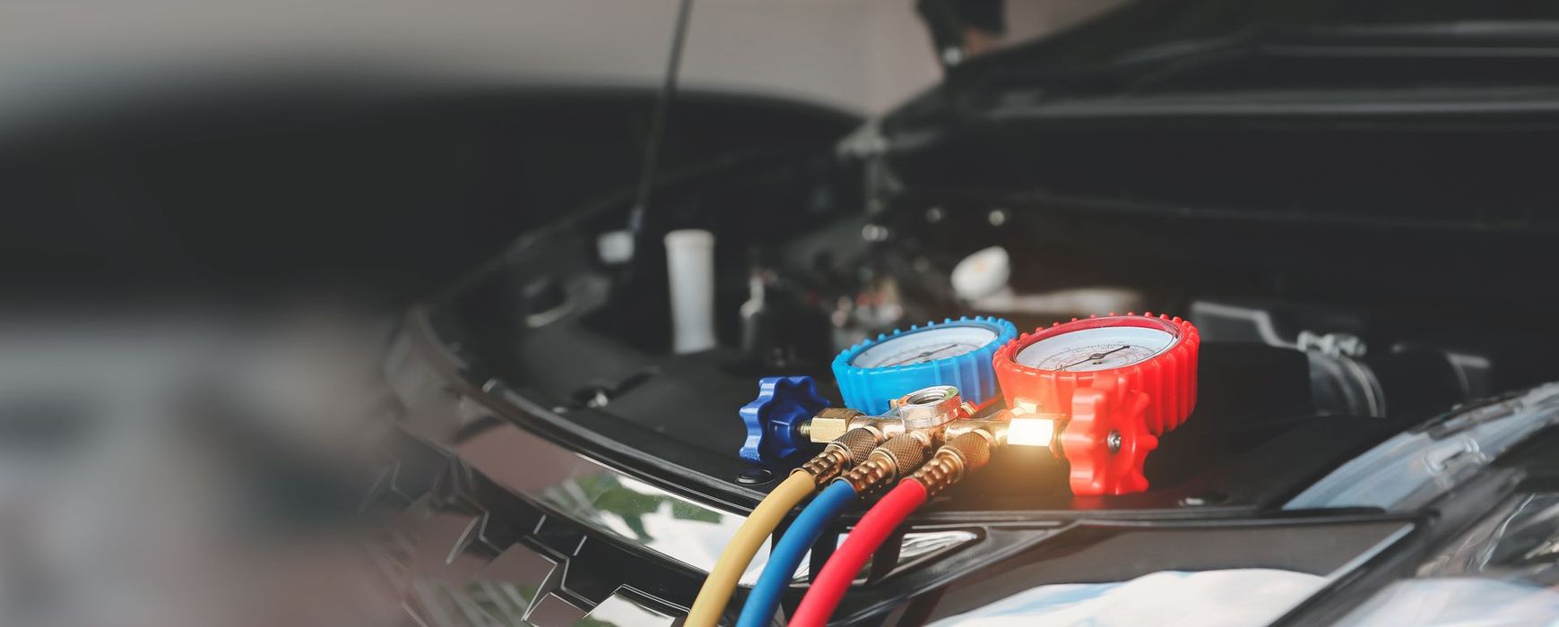 A close up of a car engine with gauges attached to it.